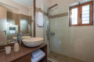 a bathroom with a sink and a glass shower at Seafront Marine Villa with private sea access - Iris Villas Lefkada in Sivota +44 photos