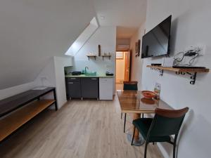 a living room with a table and a kitchen at Slovenian House Vida in Bled