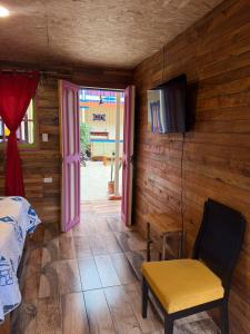 a room with a bed and a tv and a chair at Hotel Areca in Murillo