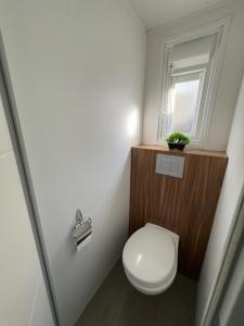 a small bathroom with a toilet and a window at Nadege in Lège-Cap-Ferret