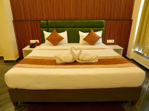 two swans towels sitting on a bed in a hotel room at Tulsi Resort in Gorakhpur