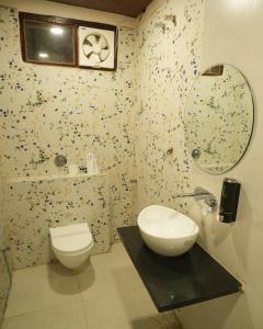 a bathroom with a toilet and a sink and a mirror at Tulsi Resort in Gorakhpur