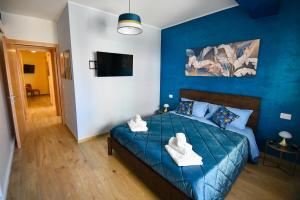 a blue bedroom with a bed with towels on it at B&B Maison Glenì in Isernia