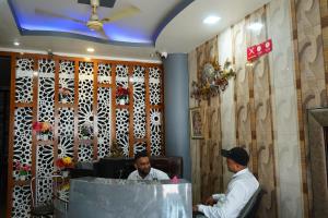 two men sitting at a counter in a restaurant at Hotel The Bliss Near Housing Board Chowk Mani Majra Chandigarh in Chandīgarh
