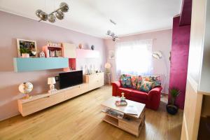 a living room with a red couch and a tv at B&B Maison Glenì in Isernia