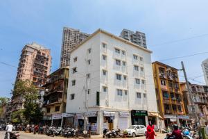 a white building on a city street with buildings at Imperial Hotel Near Haji Ali in Mumbai