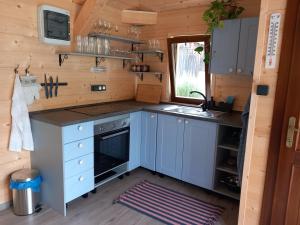 a kitchen with blue cabinets and a sink at Lotrinský Apartmány in Hodruša
