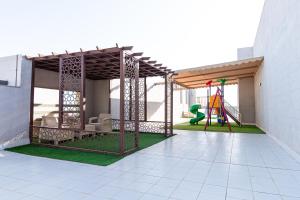 a pavilion with a playground in a building at Hasanah Suites Serviced Apartment- شقق أجنحة حسنة للشقق المخدومة in Medina