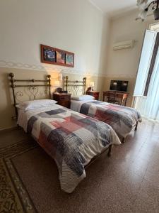 two beds sitting in a room with at Albergo Cavour in Palermo