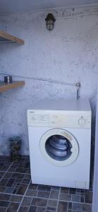 a white washing machine in a room with a wall at Margherita's holidays home in Agios Spiridon Fokidas