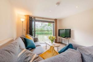 a living room with a couch and a television at The Boathouse in Biddenden
