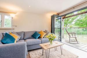 a living room with a blue couch and a table at The Boathouse in Biddenden
