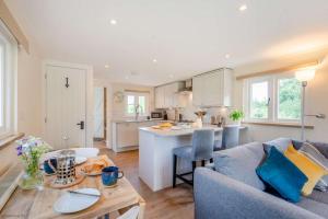 a kitchen and living room with a couch and a table at The Boathouse in Biddenden