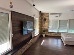 a living room with a flat screen tv on a wall at Apartmani Petra Bezdan in Bezdan