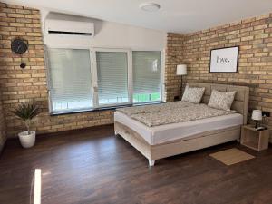 a bedroom with a bed and a brick wall at Apartmani Petra Bezdan in Bezdan