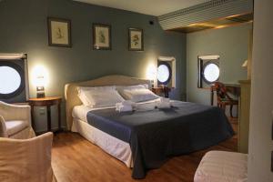 a bedroom with a bed and two chairs and two windows at The Tower in Torreglia +65 photos