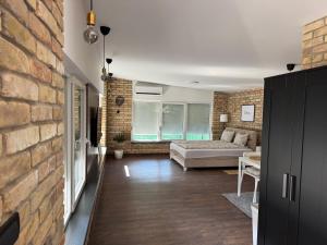 a living room with a couch and a brick wall at Apartmani Petra Bezdan in Bezdan
