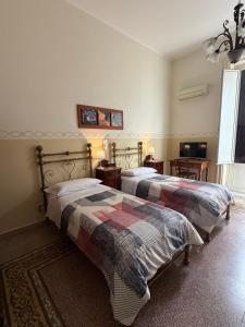 a bedroom with two beds and a window at Albergo Cavour in Palermo +15 photos