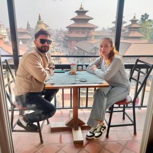 a man and a woman sitting at a table at Lalit Heritage Home in Pātan