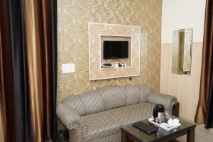 a living room with a couch and a tv on a wall at Hotel The Bliss Near Housing Board Chowk Mani Majra Chandigarh in Chandīgarh