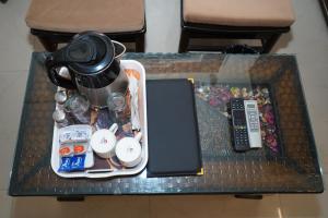 a table with a tray with a tea pot and a remote control at Hotel The Bliss Near Housing Board Chowk Mani Majra Chandigarh in Chandīgarh