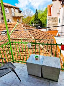 a table and a chair on a balcony with a roof at Croparadise Central in Split