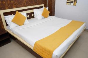 a large bed with yellow and white pillows on it at Hotel The Bliss Near Housing Board Chowk Mani Majra Chandigarh in Chandīgarh +45 photos