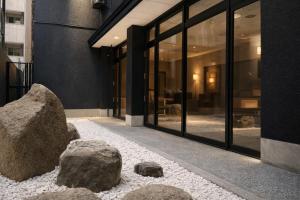 a building with two large rocks in front of it at 心斎橋難波関空直通 Ambers Hostel in Osaka +30 photos