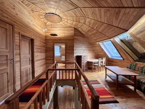 a room with a wooden ceiling with a staircase and a table at The Forest Sea Dome in Varna City