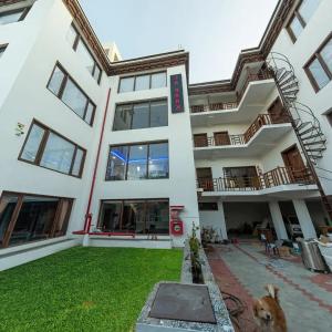a building with a dog in front of it at Hotel La Park, Leh in Leh