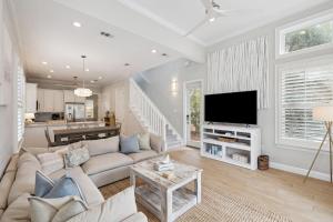 a living room with a couch and a flat screen tv at Sweet Bay on 30A in Seagrove Beach