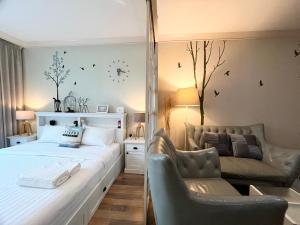 a bedroom with a bed and a couch and a chair at My Resort Condo in Hua Hin E204 in Hua Hin +55 photos