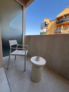 a table and a chair on a balcony with a lighthouse at Djuric Apartmani in Zaječar