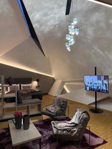 a living room with a couch and a tv at DION Hotel Wattens in Wattens