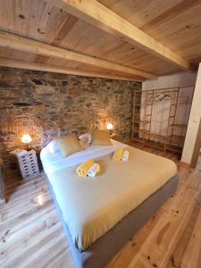 a large bed in a room with wooden ceilings at Pátio do Tear in Sobreira Formosa