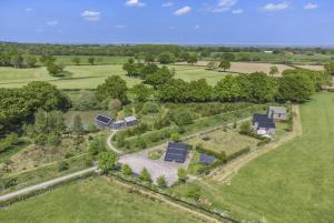 an aerial view of a house in a field with trees at The Warren in Biddenden