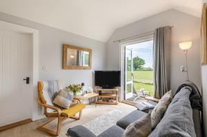 a living room with a couch and a tv at The Warren in Biddenden