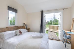 a bedroom with a bed and a large window at The Warren in Biddenden