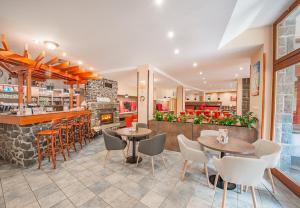 a restaurant with tables and chairs and a bar at Relax hotel FIM in Belá