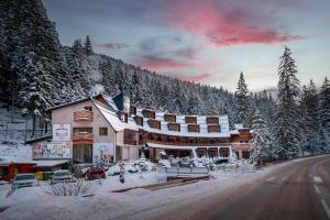 a large building in the snow on a road at Relax hotel FIM in Belá