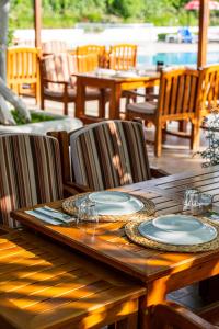 a wooden table with plates on it on a patio at Gokcen Hotel & Apartments in Oludeniz