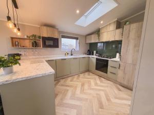 a large kitchen with wooden floors and a skylight at Sycamore Lodge in Bassenthwaite