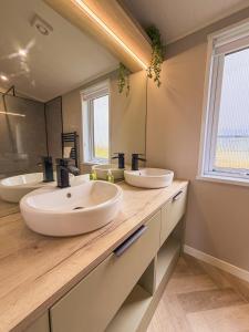 a bathroom with two sinks and a large mirror at Sycamore Lodge in Bassenthwaite