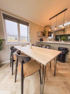 a kitchen with a large wooden table and chairs at Sycamore Lodge in Bassenthwaite +7 photos