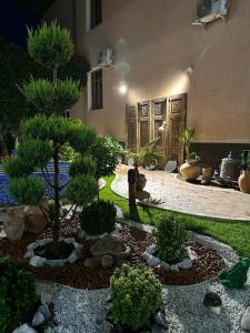 a garden with trees and plants in front of a building at Hotel B&S Samarkand Boutique in Samarkand