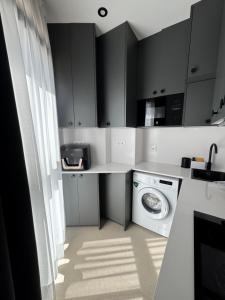 a kitchen with black cabinets and a washing machine at MINA MAR 1ª línea playa ADULTS ONLY in Vinarós +16 photos