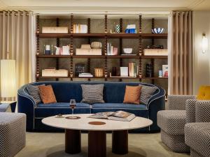 a living room with a blue couch and a table at Hotel Faubourg Galant Paris - Handwritten Collection in Paris