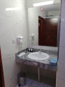 a bathroom with a sink and a mirror at Nilufer AlHada Hotel - فندق نيلوفر الهدا in Taif +22 photos