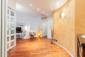 a living room with a wooden floor and white walls at Hostdomus - Salsedine Apartment in Alassio