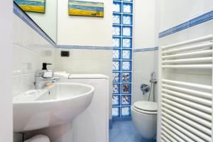 a bathroom with a sink and a toilet at Hostdomus - Salsedine Apartment in Alassio +10 photos